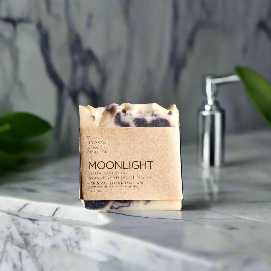 Bar of soap with a 'Moonlight' label on a bathroom marble sink.