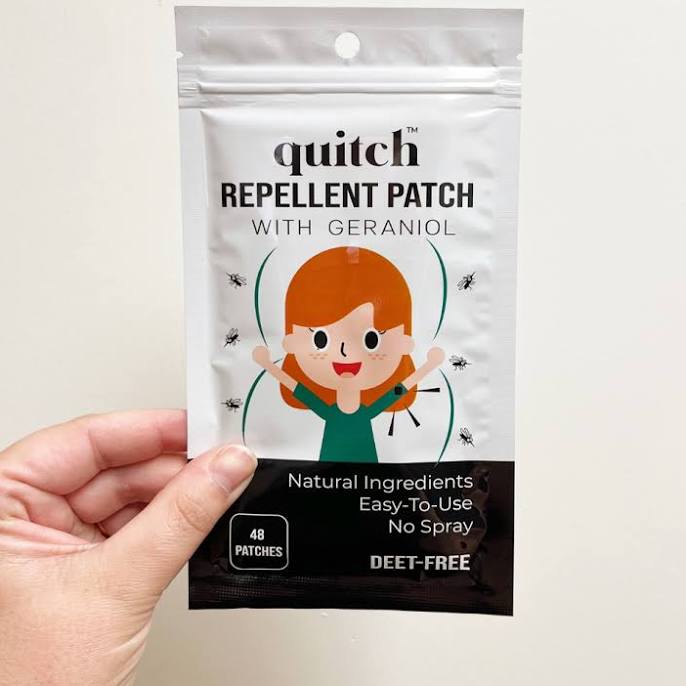 Quitch Deet Free Bug Repellent Patches for the whole family packaging held by a hand on a light background