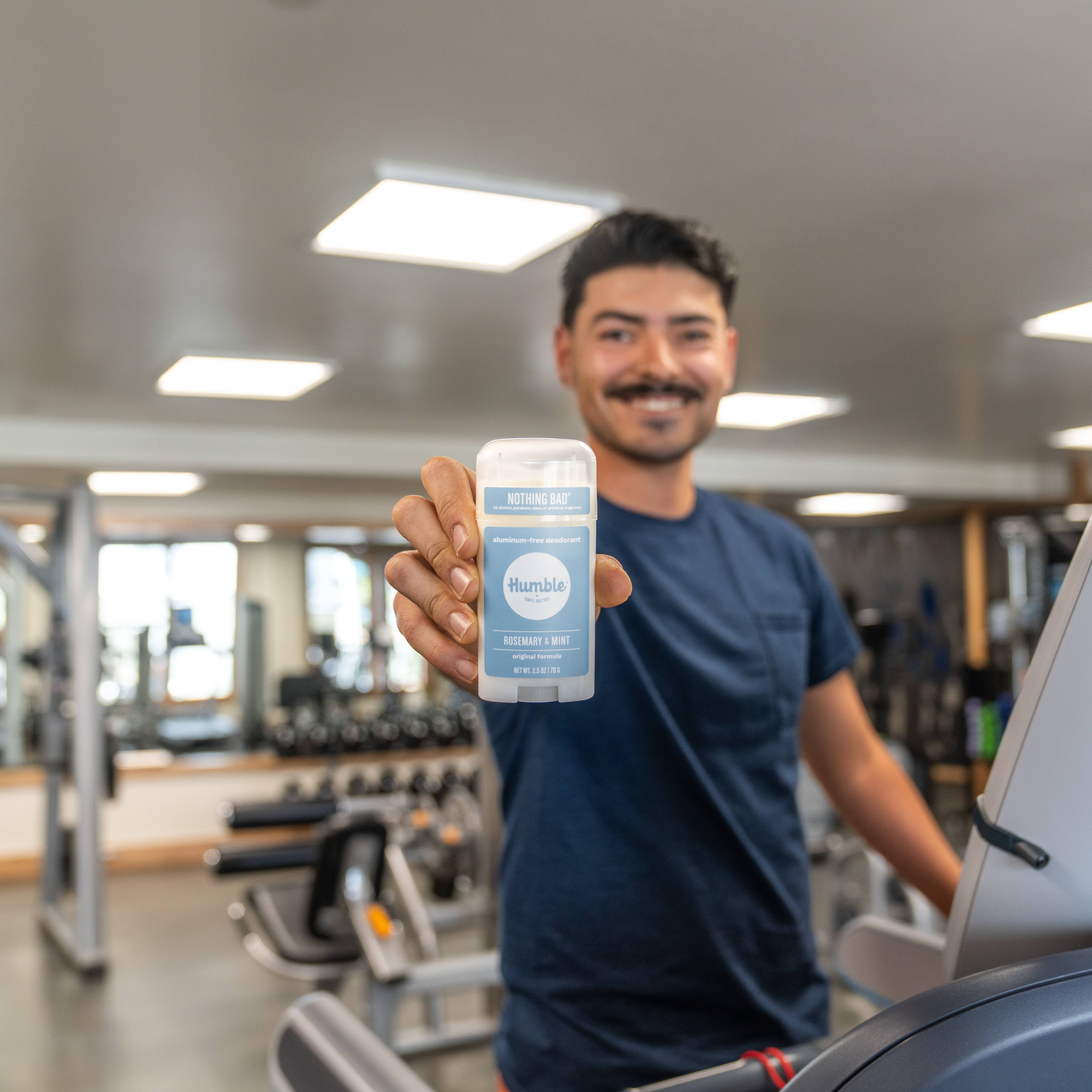 Man in a gym holding Humble original formula deodorant – Rosemary & Mint  scent, aluminum free www.aromathyme.com 