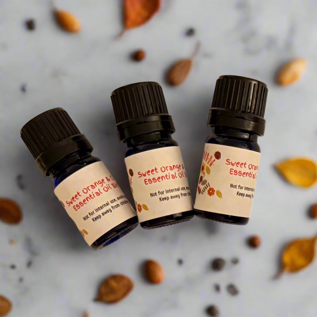 Three bottles of Sweet Orange Essential Oil Blend with labels on a beige background
